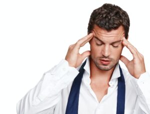A young man suffering from a rooting headache while isolated on white