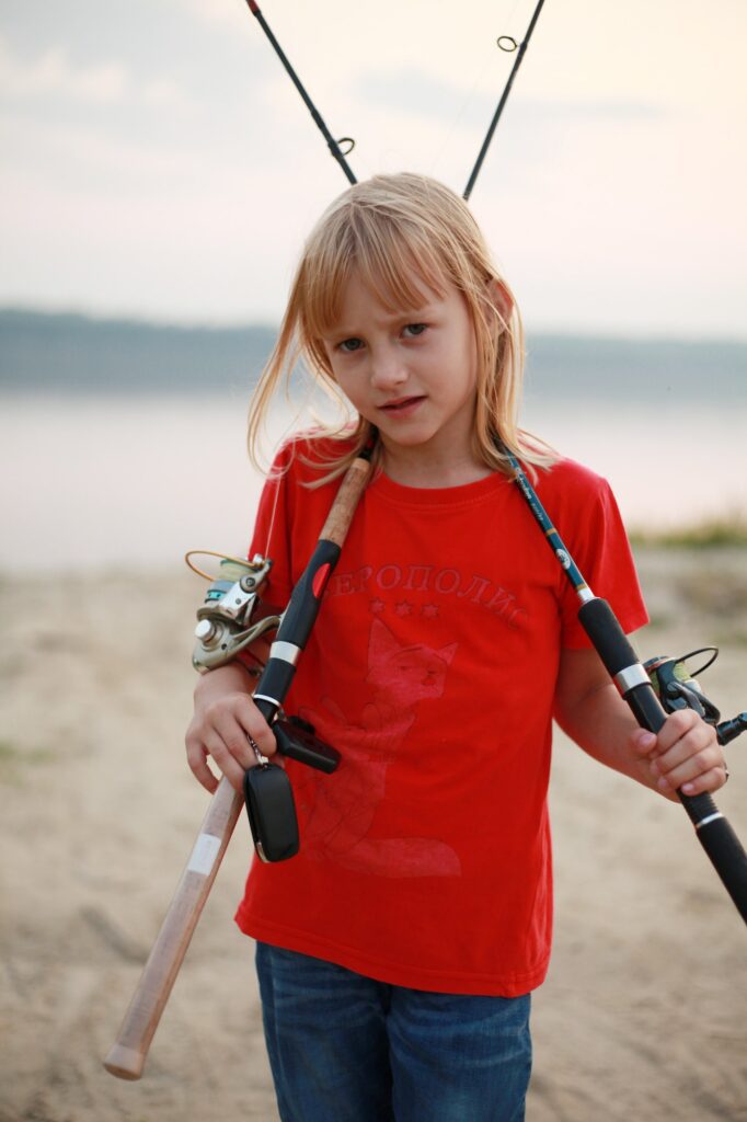 A 7-year-old girl fishing with fishing rods.