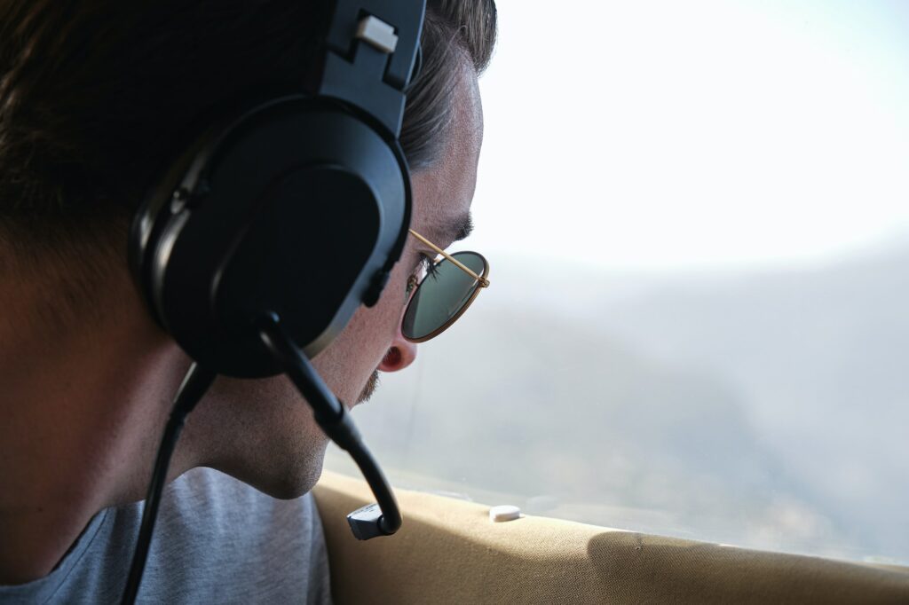 Young stylish guy observing mountains during flight