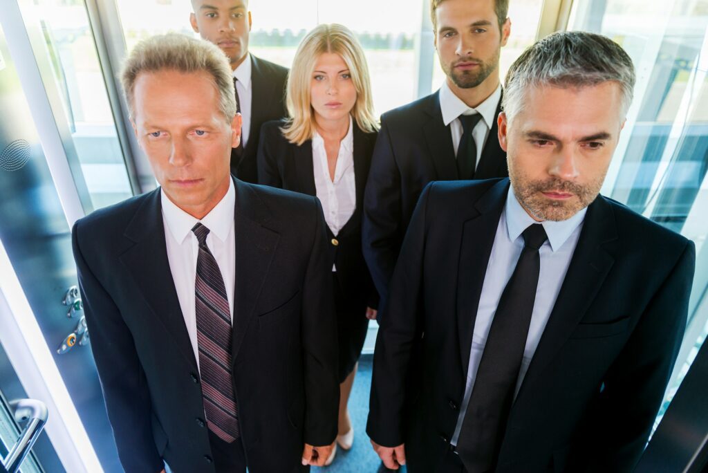 People in elevator. Top view of business people in formalwear standing in elevator